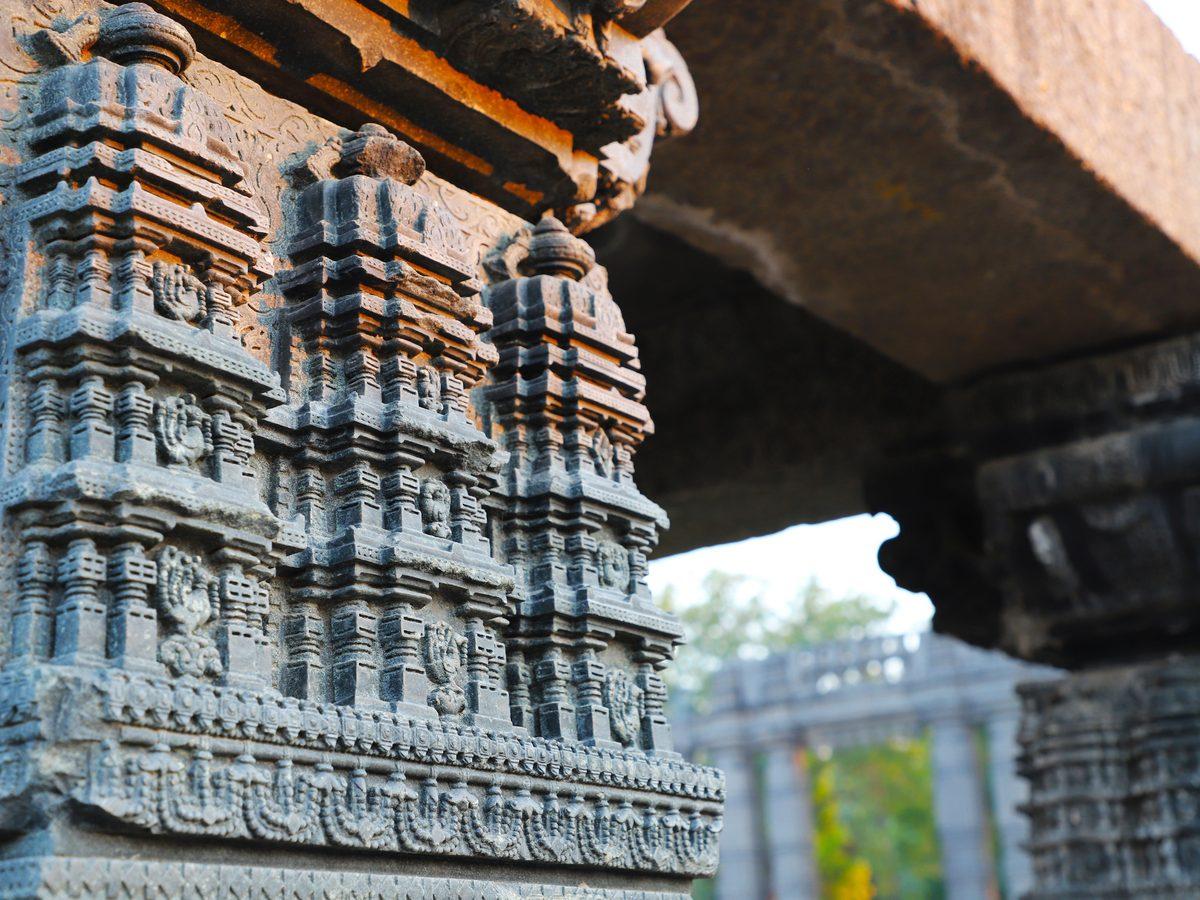 Intricately carved weathered stone on a heritage structure, showcasing the craftsmanship VIRASAT works to preserve